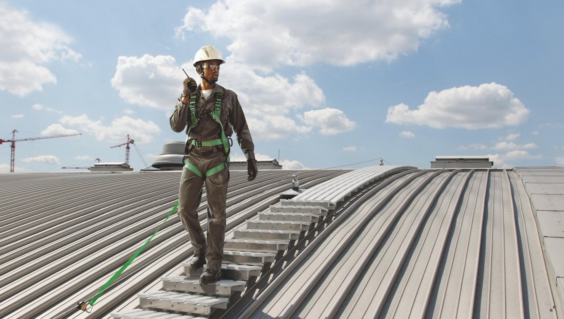 Worker in harness on rooftop walkway